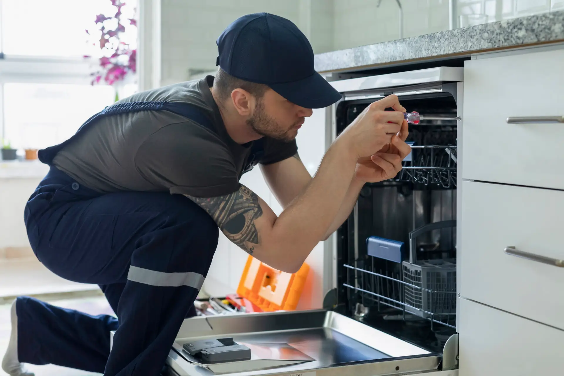 Technician repairing the spray arm of a built-in dishwasher